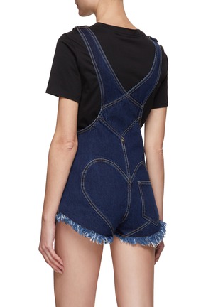 AREA 这款背带短裤将品牌标志性的仿水晶金属扣饰融入设计，将其化用为圆顶铆钉打造出心形镂空设计，为蓝色单品带来精致闪亮一笔，轻松打造你的吸睛时尚造型。展示图