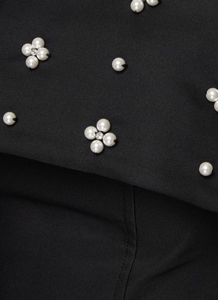 MING MA 在2018年创立了同名品牌，以“An Instinct for Surprise”为理念，运用立体剪裁及垂褶细节打造富雕塑感的服饰。这款连衣裙凭借利落的剪裁呈现出颇具立体感的廓形，上身修身版型与挺阔下摆相得益彰，珠饰衬于黑色主调之上，更添精致气息，瞬间提升时尚造型的吸睛指数。展示图