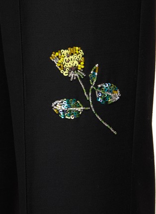MING MA 在2018年创立了同名品牌，以“An Instinct for Surprise”为理念，运用立体剪裁及垂褶细节打造富雕塑感的服饰。这款长裤凭借利落的剪裁呈现出颇具立体感的廓形，珠饰花卉图案衬于黑色主调之上，更添精致气息，瞬间提升时尚造型的吸睛指数。展示图