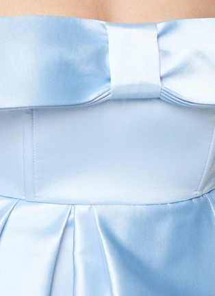 MING MA 在2018年创立了同名品牌，以“An Instinct for Surprise”为理念，运用立体剪裁及垂褶细节打造富雕塑感的服饰。这款连衣裙精选颇具光泽感的缎面面料制作，并以品牌经典的蝴蝶结元素点亮设计，结合弧状下摆，轻松勾勒出优雅的廓形线条，浅蓝色清新水润，瞬间提升时尚造型的吸睛指数。展示图